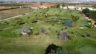 an aerial view of a golf course with trees and a pond at Cosy Loft's Valencia in Catarroja