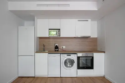 a kitchen with white cabinets and a washing machine at NEW DUPLEX, 2 WC, FRENTE CIUDAD DE LAS CIENCIAS Y LAS ARTES in Valencia