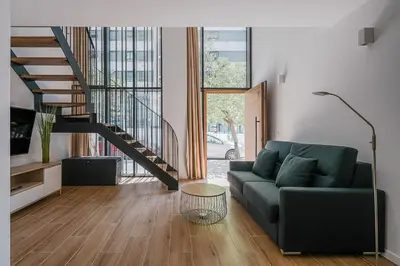 a living room with a couch and a staircase at NEW DUPLEX, 2 WC, FRENTE CIUDAD DE LAS CIENCIAS Y LAS ARTES in Valencia