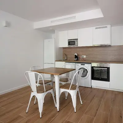 a kitchen with a table and chairs in a room at NEW DUPLEX, 2 WC, FRENTE CIUDAD DE LAS CIENCIAS Y LAS ARTES in Valencia