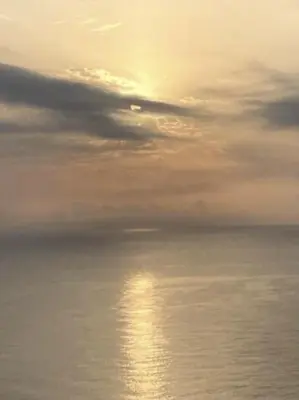 a sunset over the ocean with the sun reflecting in the water at Comfortable and Elegant Seafront Apartment in Faro de Cullera