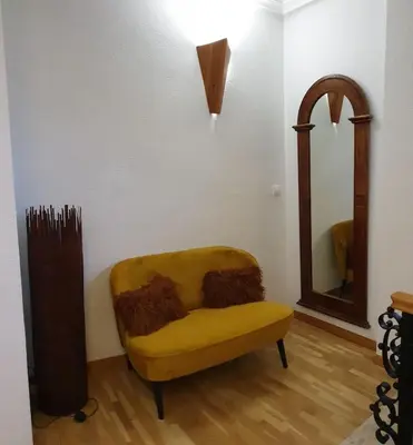 a yellow chair in a room with a mirror at Casa Cosy in Serra