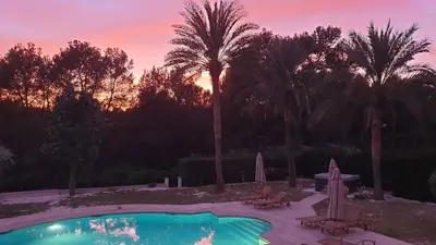 a swimming pool with a sunset in the background at Casa Cosy in Serra