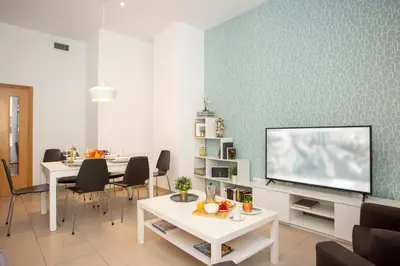 a living room with a tv and a table with chairs at SingularStays Mar44 in Valencia