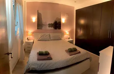 a bedroom with a large bed with two towels on it at Cosy and Modern Puerto de Sagunto Holiday Flat in Puerto de Sagunto