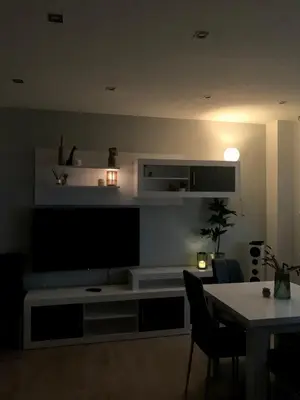 a living room with a large television and a table at Cosy and Modern Puerto de Sagunto Holiday Flat in Puerto de Sagunto