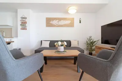 a living room with a couch and a table with chairs at Global Vacacional, Apartamento de 2 habitaciones con terraza y vistas al mar in Canet de Berenguer