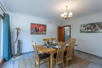 a dining room with a wooden table and chairs at VILLA LATEL in Serra