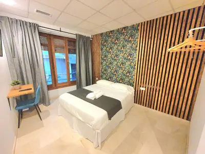a bedroom with a bed and a desk and window at PLAZA HOME ResEst in Valencia