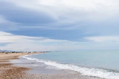 a beach with the ocean and people on it at Tranquilidad a 2 minutos del mar in Canet de Berenguer