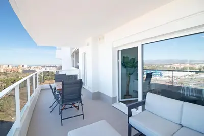 a balcony with a couch and a table and chairs at Global Vacacional, Apartamento con terraza y vistas al mar y a la montaña in Canet de Berenguer