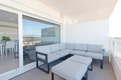 a living room with a couch and a table at Global Vacacional, Apartamento con terraza y vistas al mar y a la montaña in Canet de Berenguer