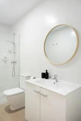 a white bathroom with a sink and a mirror at Blanq Marina Suites in Valencia