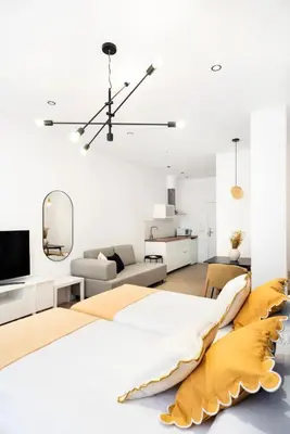 a white bedroom with a large bed and a mirror at Blanq Marina Suites in Valencia