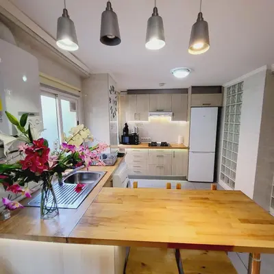 a kitchen with a wooden table with flowers on it at Pintor 31 in Valencia