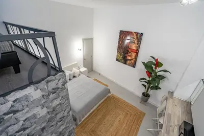 a white room with a bed and a staircase at Exquisite studio apartment with an original design in Valencia