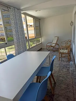 a room with a table and chairs and windows at Casa Schila in Tavernes de Valldigna