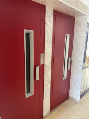 a red door in a building with two windows at Casa Schila in Tavernes de Valldigna
