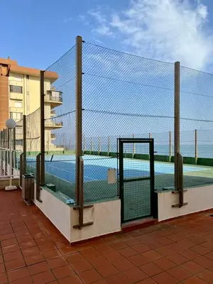 a chain link fence with a tennis court behind it at Casa Schila in Tavernes de Valldigna