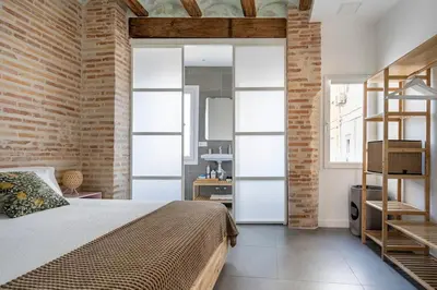 a bedroom with a bed and a brick wall at Céntrica y encantadora vivienda. in Valencia