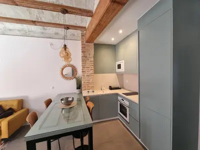 a kitchen and living room with a table and a couch at Céntrica y encantadora vivienda. in Valencia