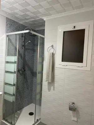 a bathroom with a shower and a television on the wall at MALVARROSA BEACH FAMILIAR in Valencia