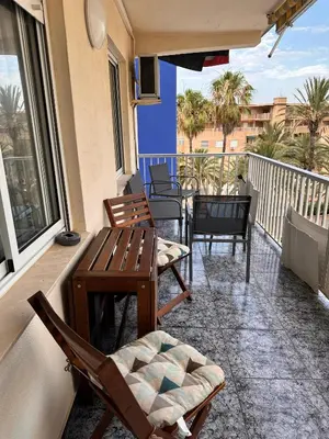 a balcony with chairs and a table on a balcony at Apartamento Tavernes Playa in Tavernes de Valldigna