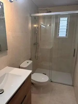 a bathroom with a shower and a toilet and a sink at Apartamento Tavernes Playa in Tavernes de Valldigna