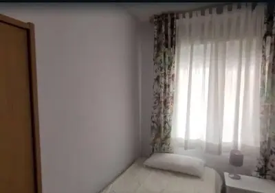 a small bedroom with a bed and a window at Apartamento Tavernes Playa in Tavernes de Valldigna