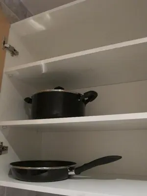 a pot and a pan on a shelf with a knife at Apartamentos Valencia in Valencia