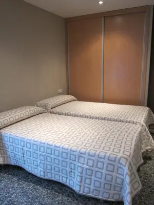 two twin beds in a room with a wall at Apartamentos Valencia in Valencia