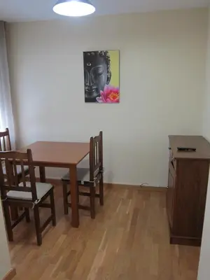 a dining room with a table and chairs and a painting at Apartamentos Valencia in Valencia