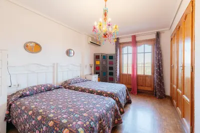 a bedroom with two beds and a chandelier at chalet, villa rodeada de naturaleza piscina a doce klm de Valencia y 7 del aeropuerto in Valencia