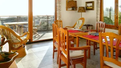 a dining room with a wooden table and chairs at Casa Catinca Cullera - Beach House On the Dune in Cullera