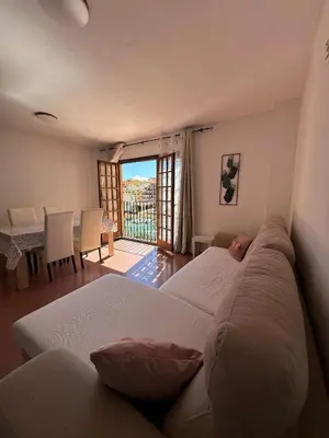 a living room with two beds and a balcony at Port Saplaya 1 Valencia in Port Saplaya