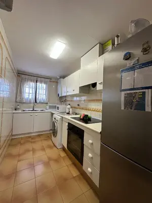 a kitchen with white cabinets and a refrigerator at Port Saplaya 1 Valencia in Port Saplaya