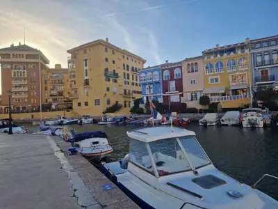 a boat is docked in a harbor with buildings at Port Saplaya 1 Valencia in Port Saplaya