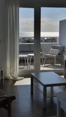 a living room with a table and a view of the ocean at Apartamento con vistas en Gran Canet in Canet de Berenguer