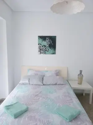 a bed with two green towels on top of it at Nice Spacious Flat in the Center in Valencia