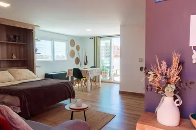 a bedroom with a bed and a vase of flowers at Precioso ático en Valencia. in Valencia
