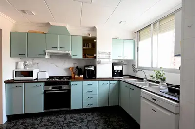 a kitchen with blue cabinets and a sink at Playa Bonita Apartment in Puerto de Sagunto