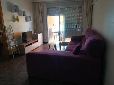 a living room with a purple couch and a tv at Mi playa in Puerto de Sagunto