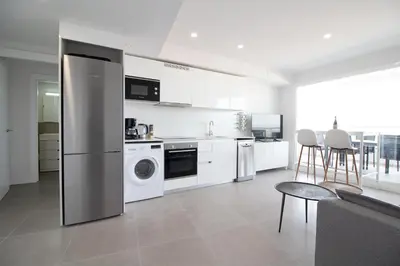 a kitchen with a refrigerator and a table and chairs at Global Vacacional, Apartamento de 2 habitaciones con gran terraza en Gran Canet in Canet de Berenguer
