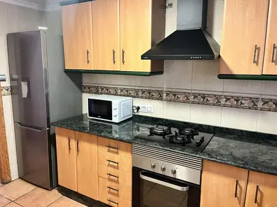 a kitchen with a stove and a microwave at Villas de descanso in Vilamarxant