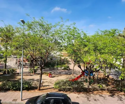 a car parked in a park with trees and a playground at Apartamento en Les Alqueries con aire acondicionado in Alquerías del Niño Perdido