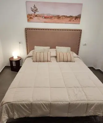 a large bed in a bedroom with a large white comforter at Apartamento en Les Alqueries con aire acondicionado in Alquerías del Niño Perdido