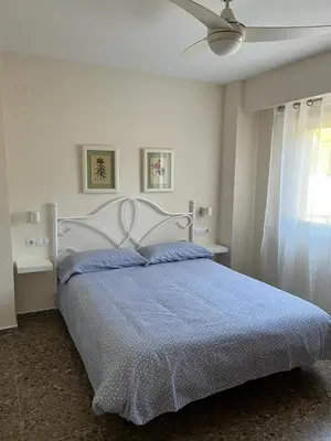 a bedroom with a large bed with a blue comforter at Apartamento familiar en Cullera - Playa el Racó in Cullera