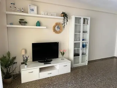 a living room with a tv on a white entertainment center at Apartamento familiar en Cullera - Playa el Racó in Cullera