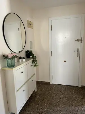 a room with a dresser with a mirror and a door at Apartamento familiar en Cullera - Playa el Racó in Cullera