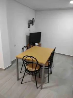 a table with two chairs and a television in a room at Casa Coletor in Chulilla
